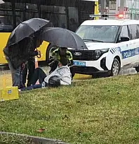 Yağmur altında ıslanan yaralıya trafik polisi şemsiye tuttu