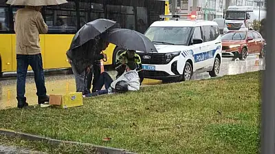 Yağmur altında ıslanan yaralıya trafik polisi şemsiye tuttu