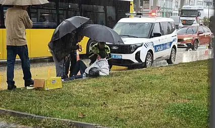 Yağmur altında ıslanan yaralıya trafik polisi şemsiye tuttu