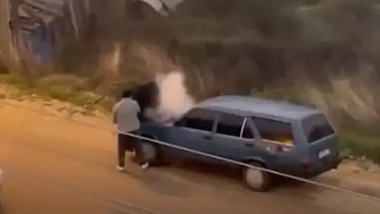 Alev alev yanan aracını kovayla su döküp söndürdü