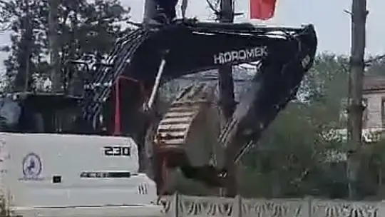İş makinesinin üzerine çıkıp Türk bayrağını düzeltti, ardından böyle öptü