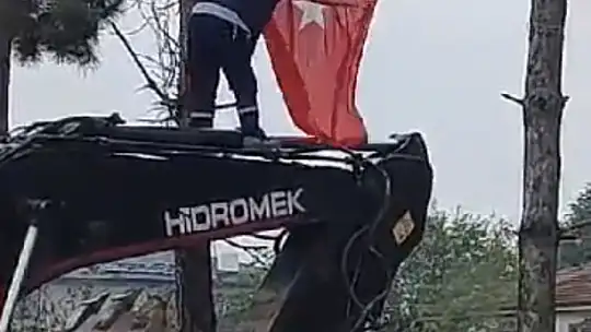 İş makinesinin üzerine çıkıp Türk bayrağını düzeltti, ardından böyle öptü