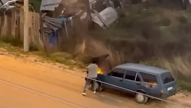 Alev alev yanan aracını kovayla su döküp söndürdü