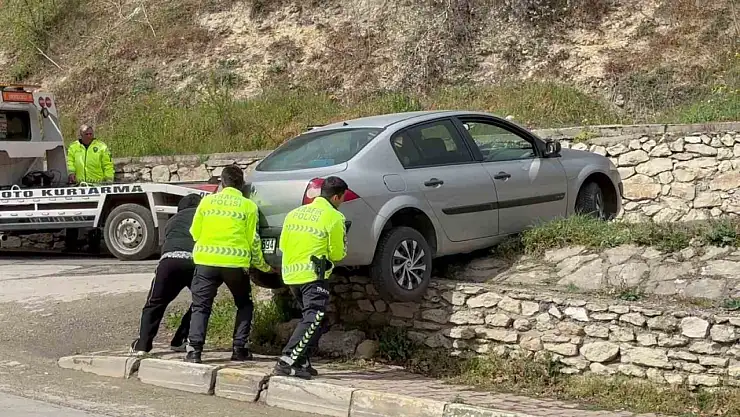 Asılı kalan otomobilini polislerin yardımıyla kurtardı