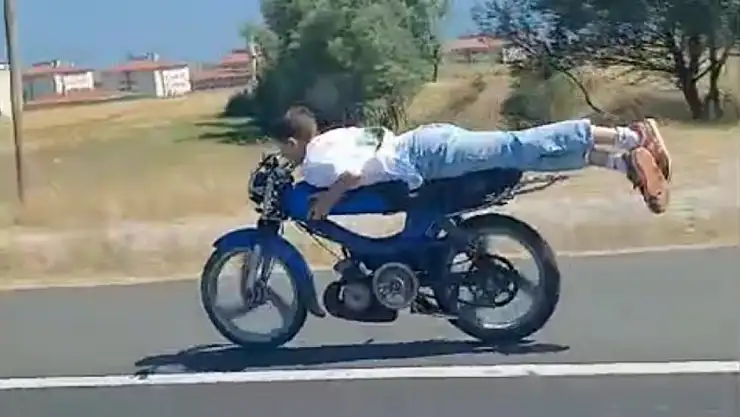 Motosikletinin üzerine yüzüstü yattı, faciaya davetiye çıkardı